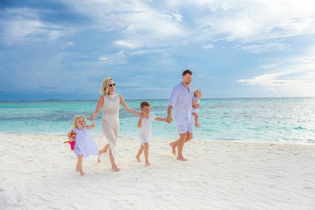 Why Moving to Florida is the Best Decision You Can Make Family enjoying a walk on a pristine beach with turquoise waters, captured in a light-hearted moment.
